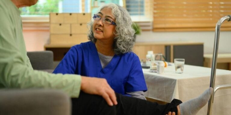 A Female Nurse Checking Up on an Injured Senior in Memory Care Home