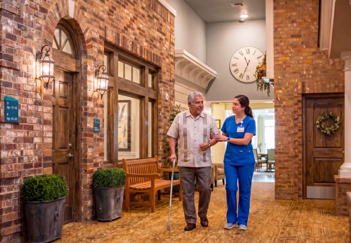 Female Nurse Walking With Elderly Resident at a Memory Care Community Female Nurse Walking With Elderly Resident at a Memory Care Community
