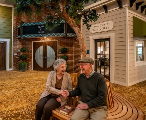 Elderly Couple Relaxing on a Bench at a Memory Care Facility Elderly Couple Relaxing on a Bench at a Memory Care Facility