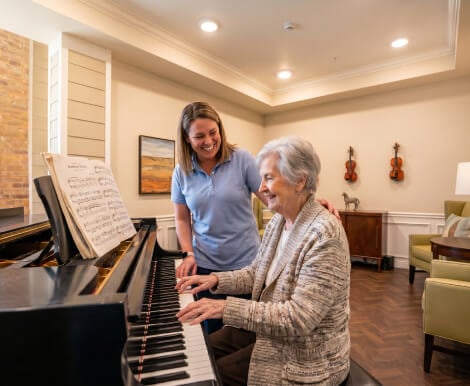 Resident Playing Piano With Caregiver at a Memory Care in Abilene Texas Resident Playing Piano With Caregiver at a Memory Care in Abilene Texas